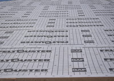 Rolls of Felt Duster roofing underlayment with measurement grid for installation guidance.